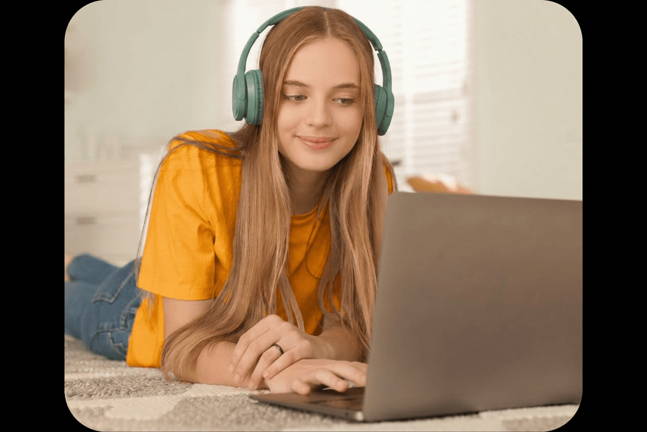 A student wearing headphones studying on a laptop